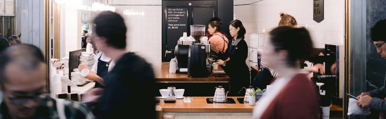 Baristas in a Melbourne cafe making coffee with customers seated