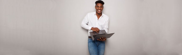 Smiling young black man holding laptop