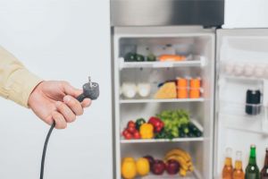 Man holding power cord to fridge 