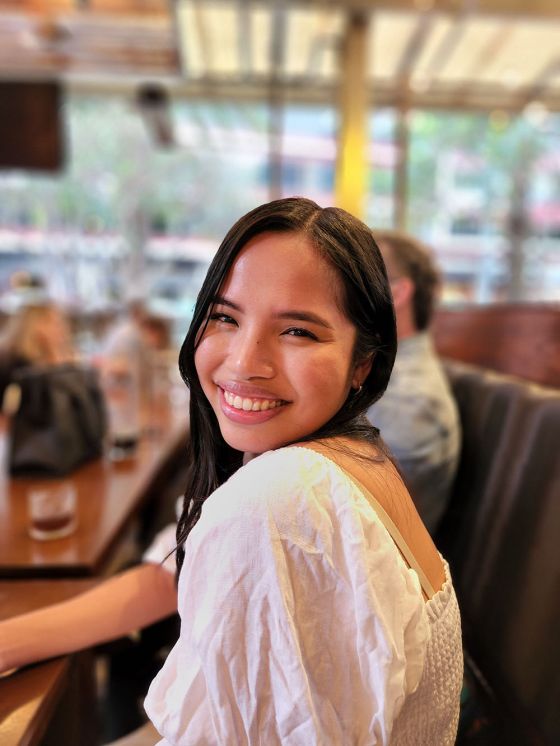 Smiling woman in white top in restaurant