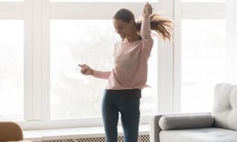 Lady celebrating in living room jumping in the air