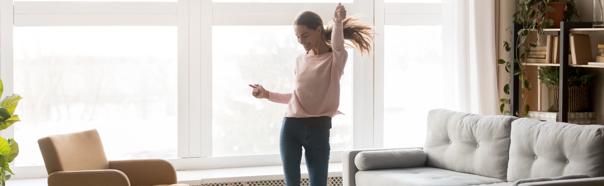 Lady celebrating in living room jumping in the air