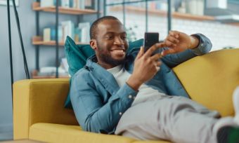 Man laying on lounge smiling at phone