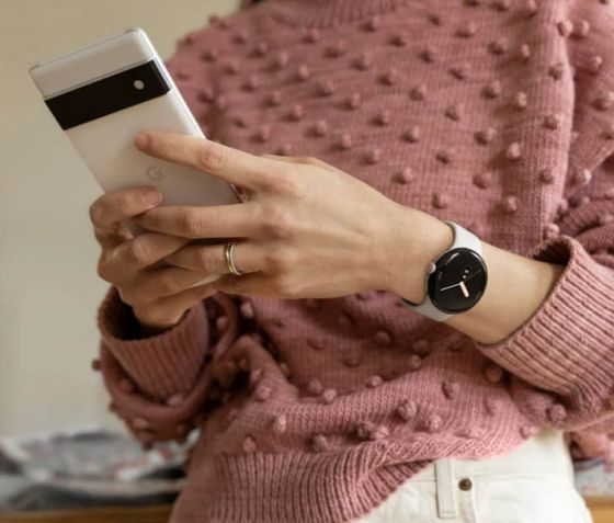 Woman wearing Pixel Watch and using Pixel phone