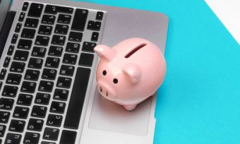 A piggy bank next to a laptop