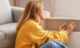 Lady getting warm in front of heater