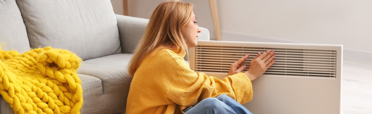 Lady getting warm in front of heater