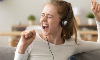 Young lady excited singing with headphones on