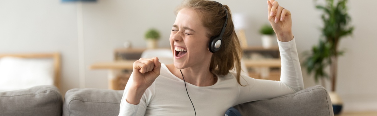 Young lady excited singing with headphones on