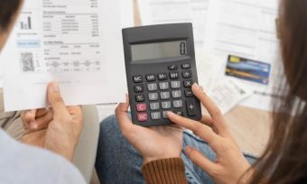 Couple looking at energy bills and working out costs with a calculator.