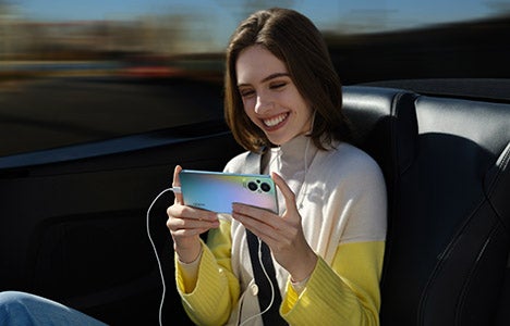 Woman using OPPO Reno8 Lite 5G phone in rainbow colourway