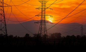 Powerlines with orange sunset in the background.