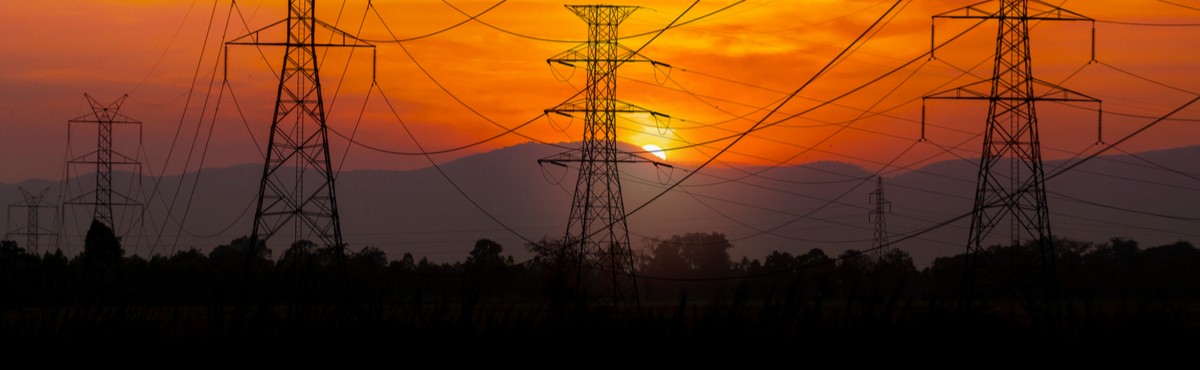 Powerlines with orange sunset in the background.