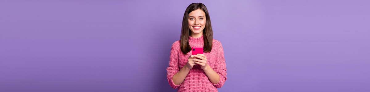 Woman holding phone in front of purple background