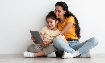 Mother and young daughter using tablet together