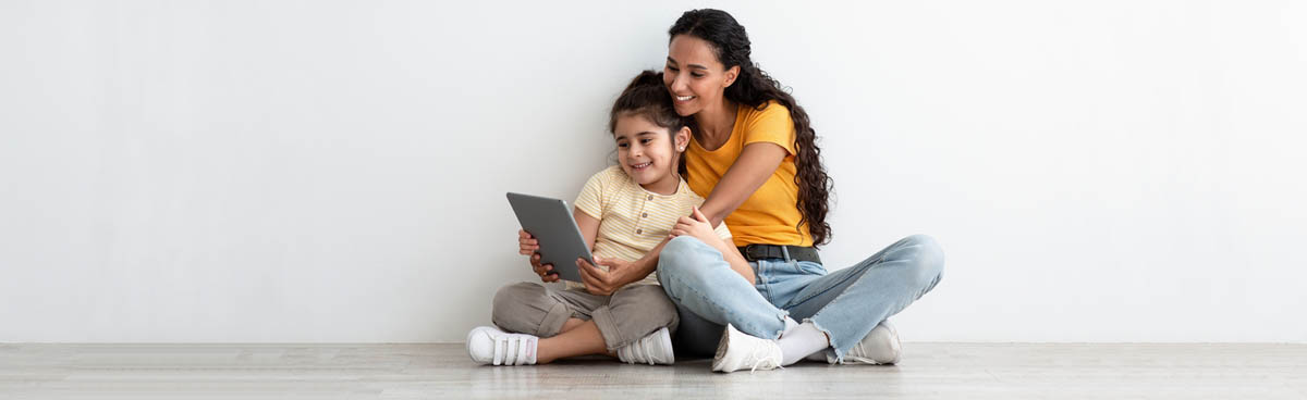 Mother and young daughter using tablet together