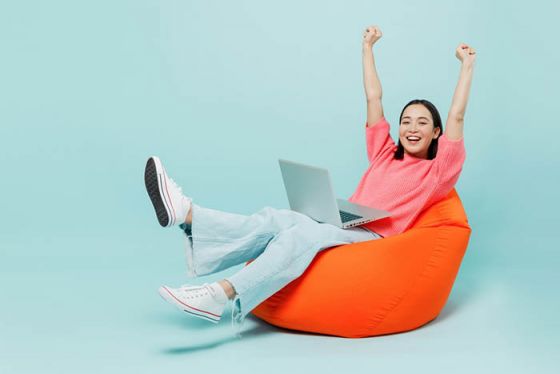 Woman using laptop in orange bean bag