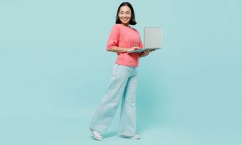 Woman in pink sweater using laptop