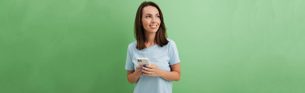 Young woman uisng phone with green background