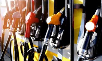 Fuel pumps at petrol station with sunlight shining on them.