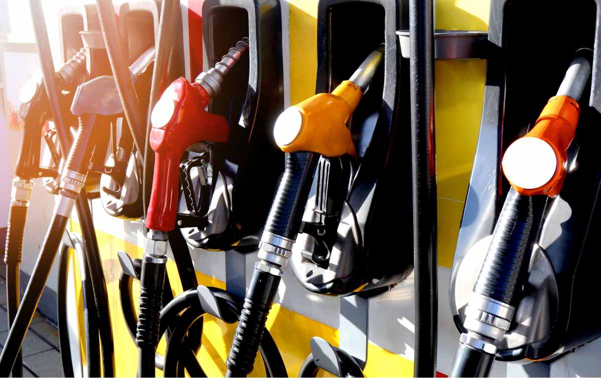 Fuel pumps at petrol station with sunlight shining on them.