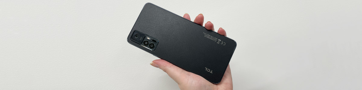 Person holding TCL 30+ phone in black