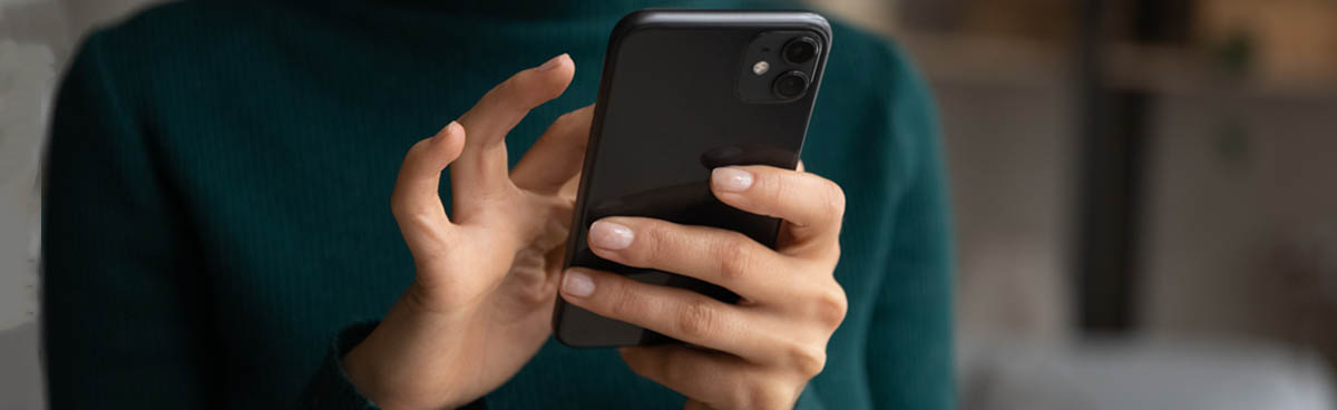 Woman's hands using black iPhone