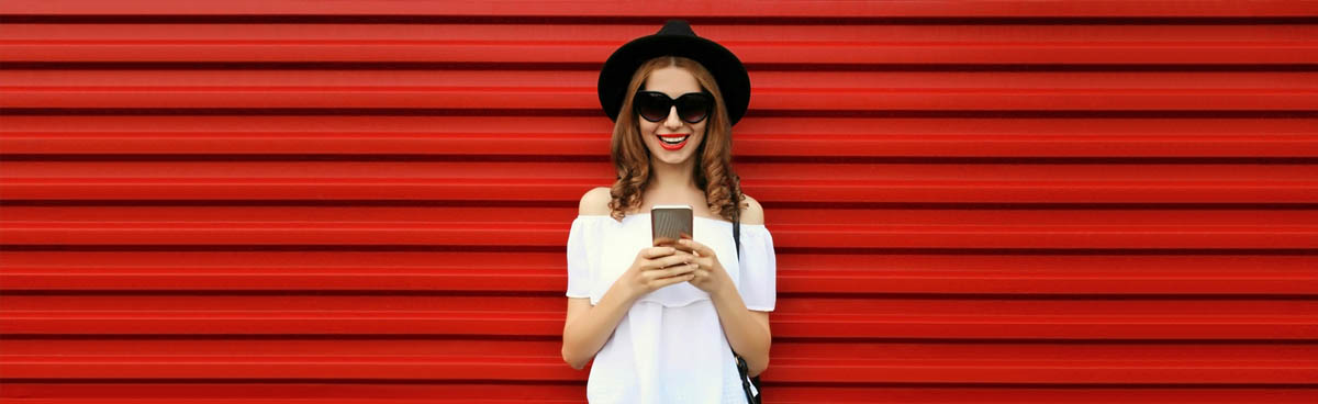 Happy woman using smartphone with red background