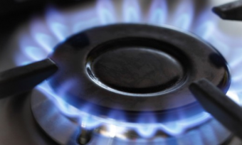 Natural gas stove top with flame on.