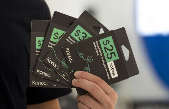 Man's hand holding Konec SIM cards