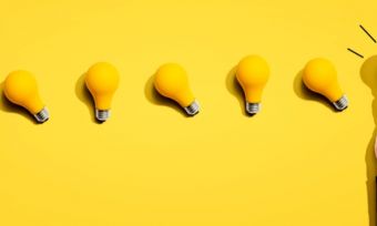 Yellow lightbulbs on a yellow background in a line.