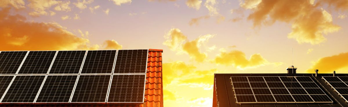 Solar on rooftops with rising sun in the background.