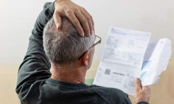 Stressed older man looking at his energy bill.