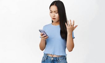 Young woman looking at smartphone angrily