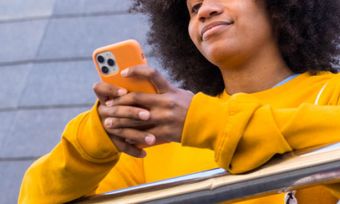 Young woman in yellow jumper using mobile phone