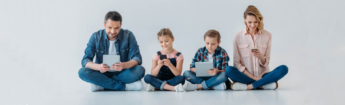 Family of four using phones and tablets together