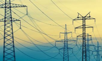 Powerlines with blue and yellow sky in the background.