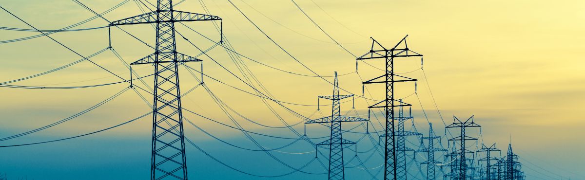 Powerlines with blue and yellow sky in the background.