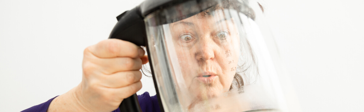 Woman looking at limescale on kettle