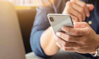 Man using mobile phone while on laptop