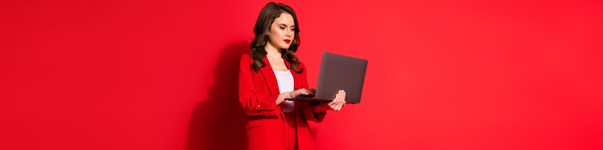 Woman holding laptop against red background