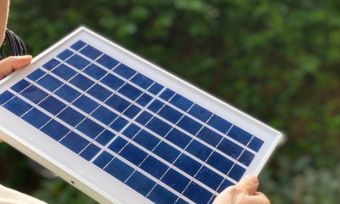 Man holding small solar panel.