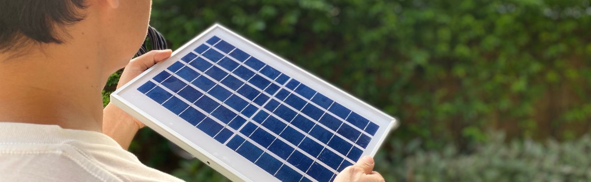 Man holding small solar panel.