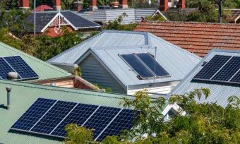 Bird's eye view of rooftop solar panels on houses in neighbourhood.