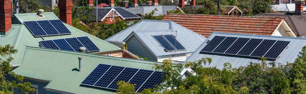 Bird's eye view of rooftop solar panels on houses in neighbourhood.