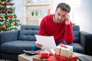 Man stressed over bill during Christmas time.