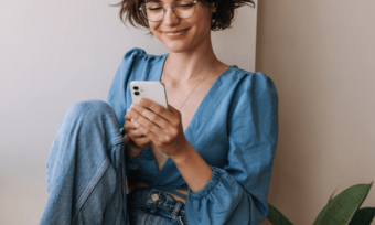Happy woman using energy app on smartphone. ENGIE/Simply energy app