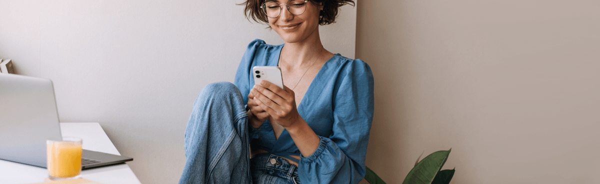 Happy woman using energy app on smartphone. ENGIE/Simply energy app