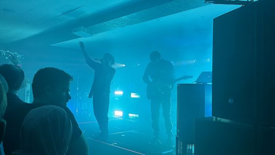 Two band members on stage with blue lighting