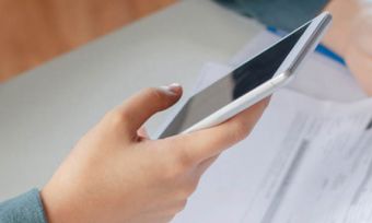 Closeup on person paying bills with smartphone